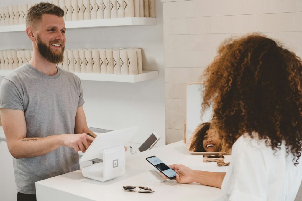 Shop owner handing a customer their order at a counter
