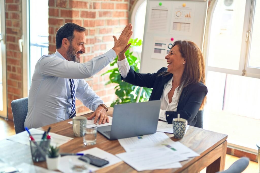 Business owner and marketer celebrating over a laptop